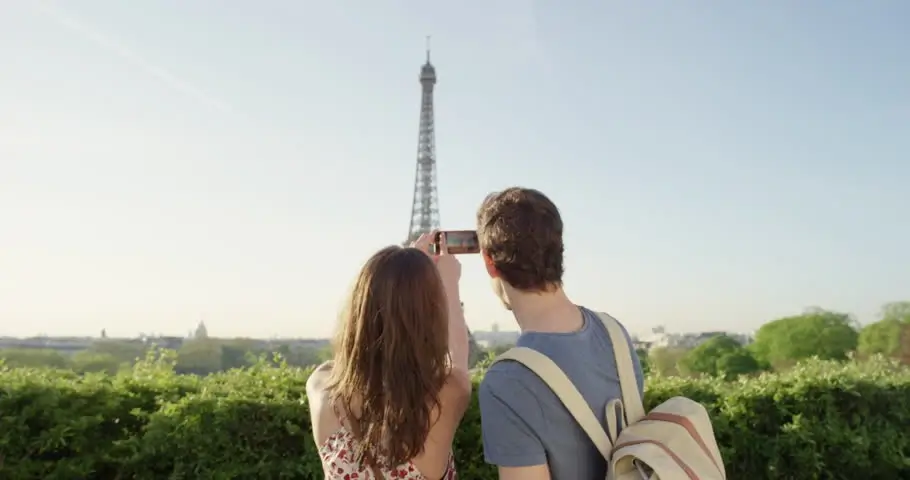 A couple looking at a map with the Eiffel Tower in the background, planning a private tour