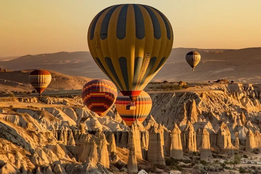 Hot air balloons flying over the unique rock formations of Cappadocia, Turkey